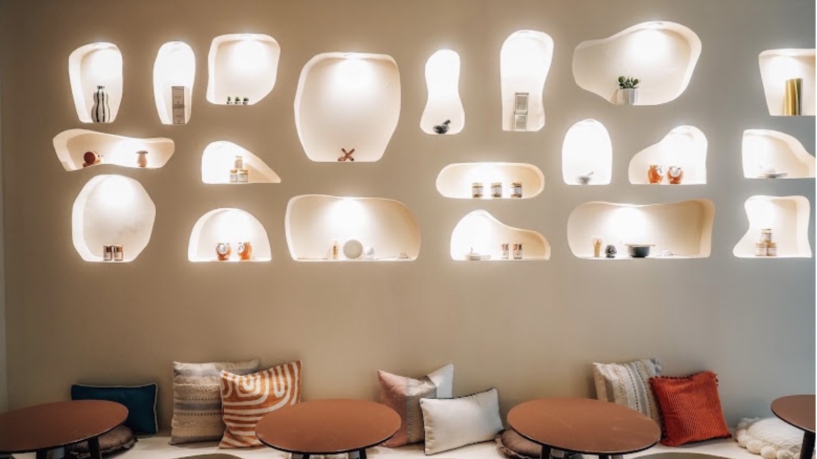 Banquette terracotta et niches lumineuses dans le coffee shop Mokha
